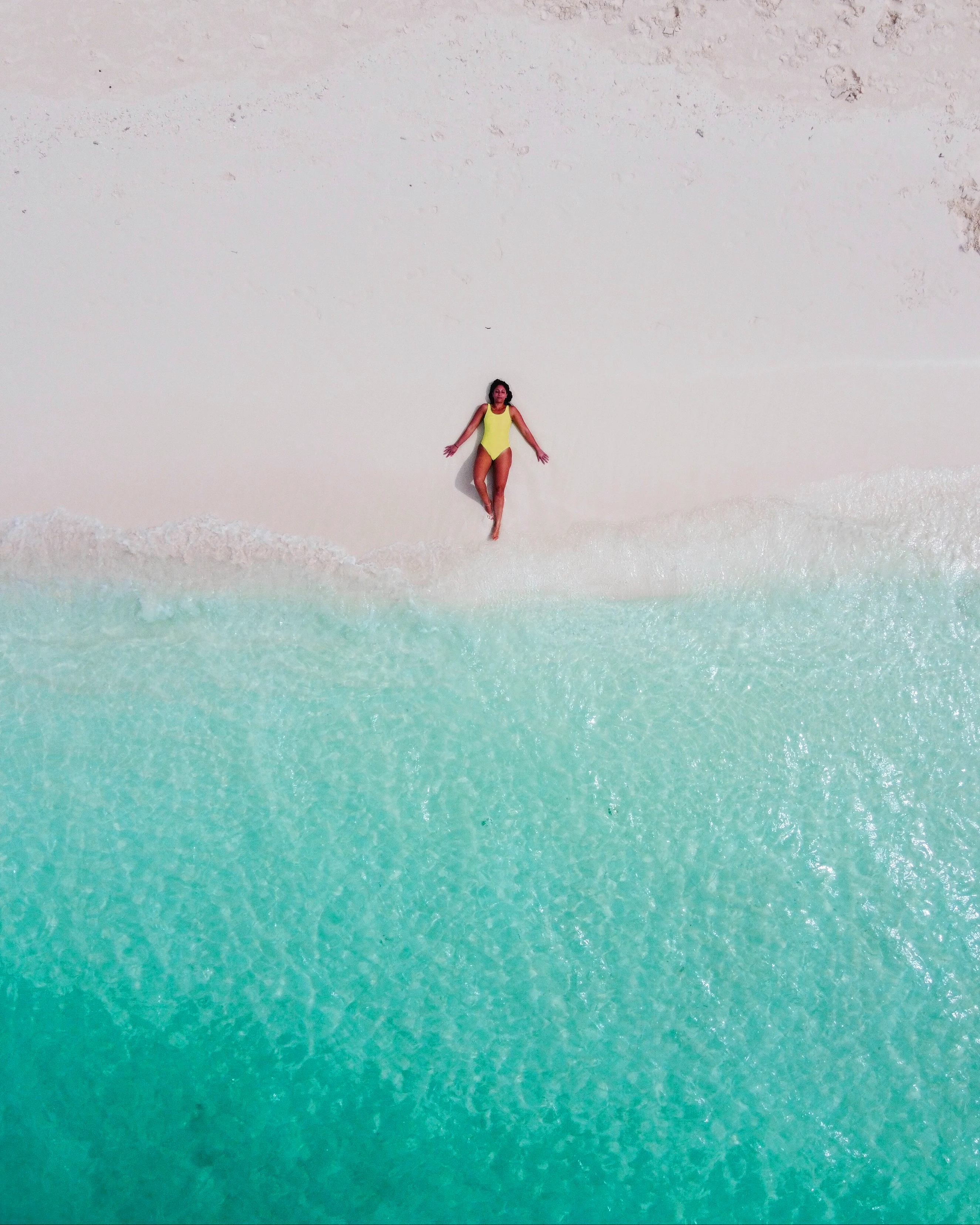 Beach with yellow umbrellas from above