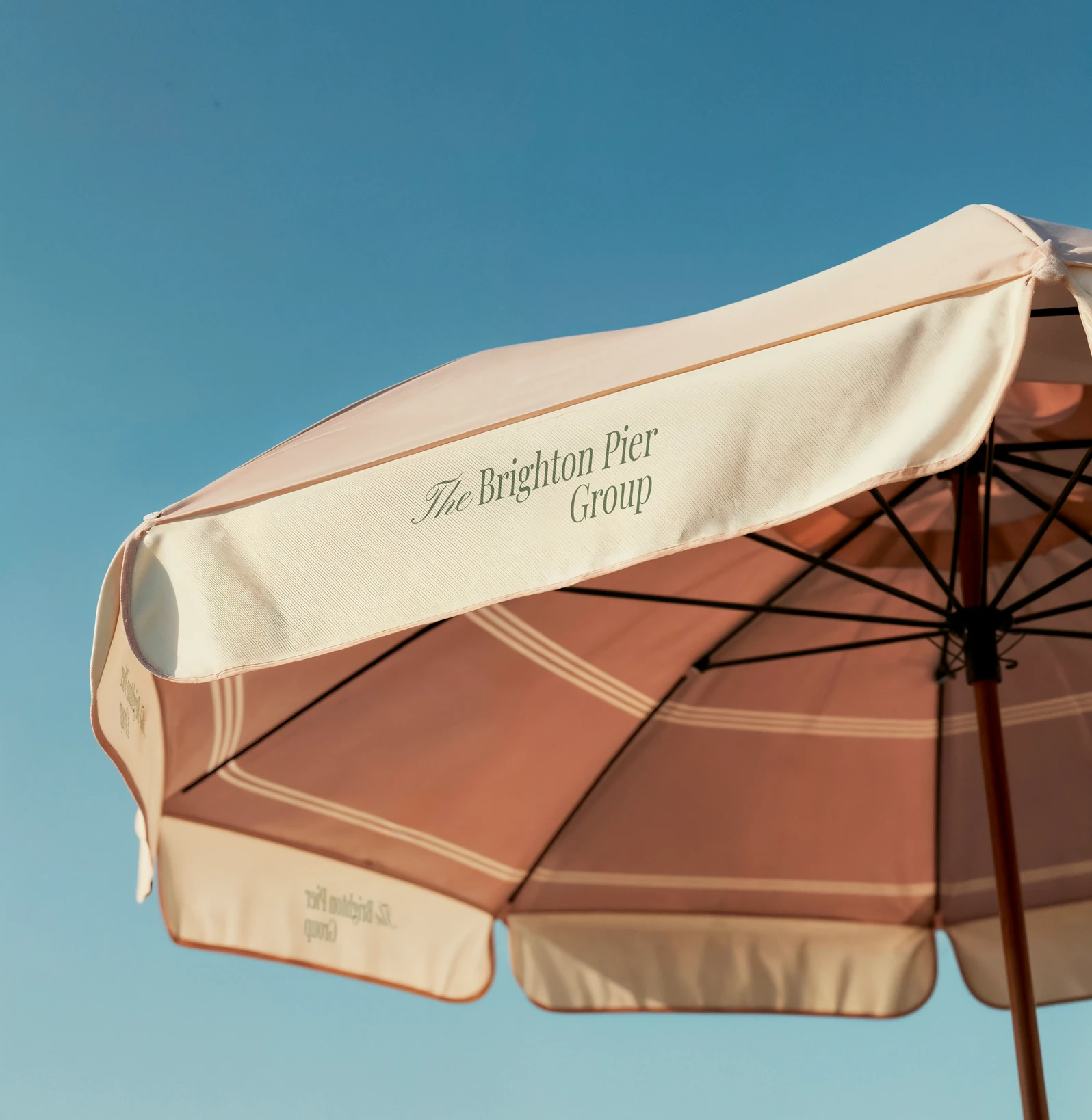 A branded parasol against a clear blue sky