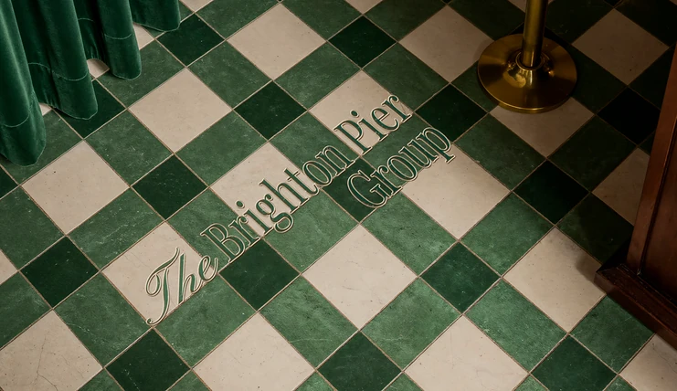 The Brighton Pier Group wordmark painted onto a green and cream chequerboard floor