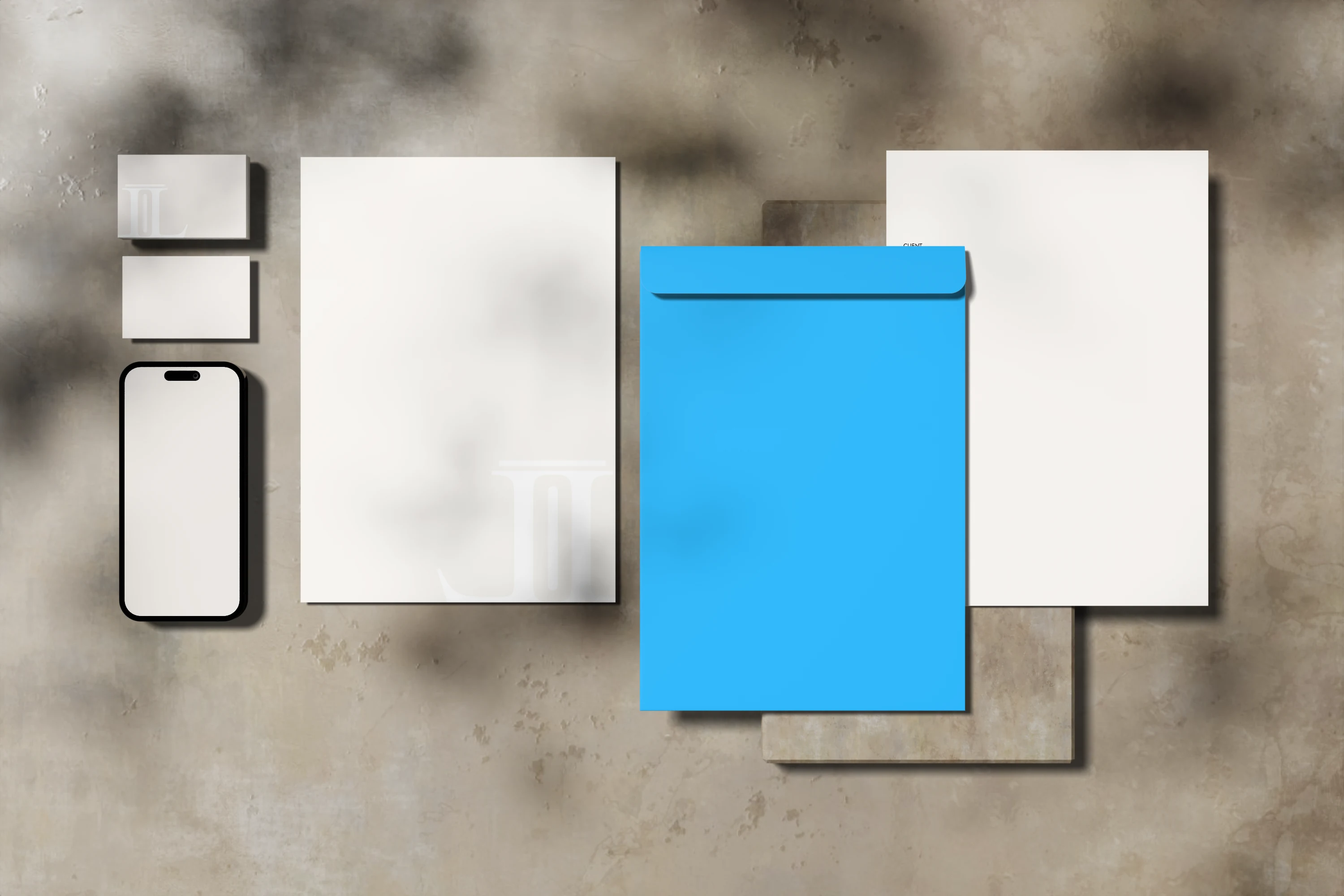 Lares letterheads, invoice, business cards and envelope laid out on stone