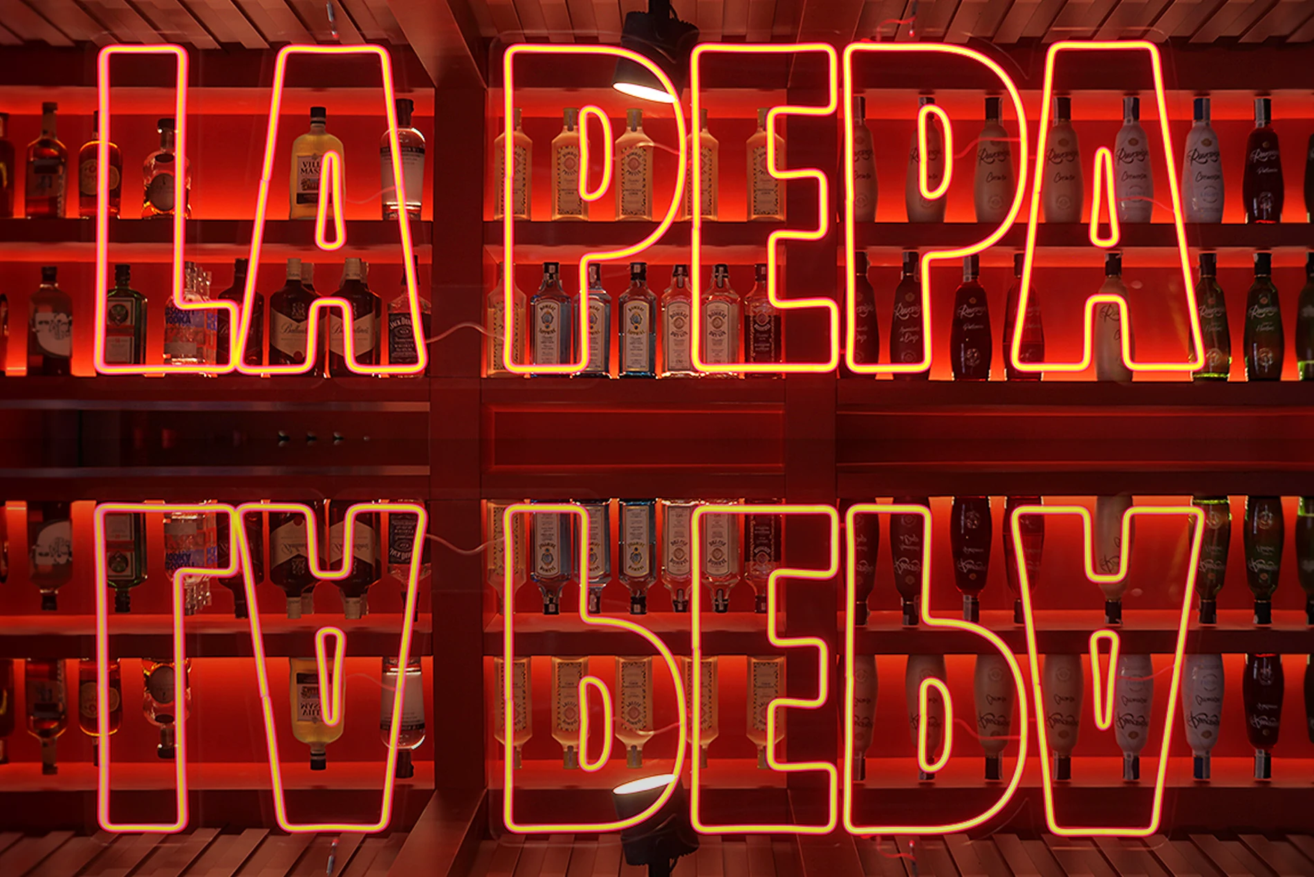 La Pepa neon wordmark over its mirrored reflection