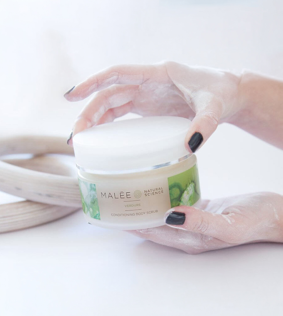 Malée Verdure conditioning body scrub held in cupped hands