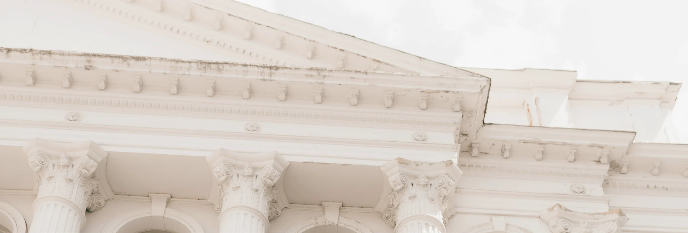 A pale classical cornice against the sky