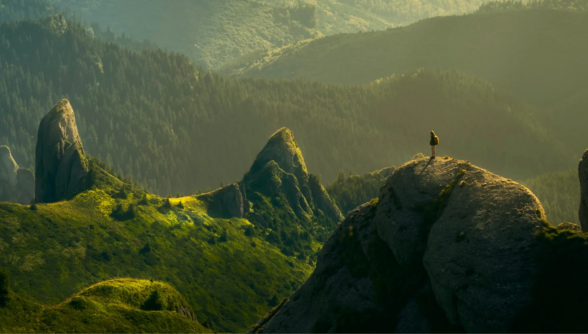 A walker on a ridge above a green valley