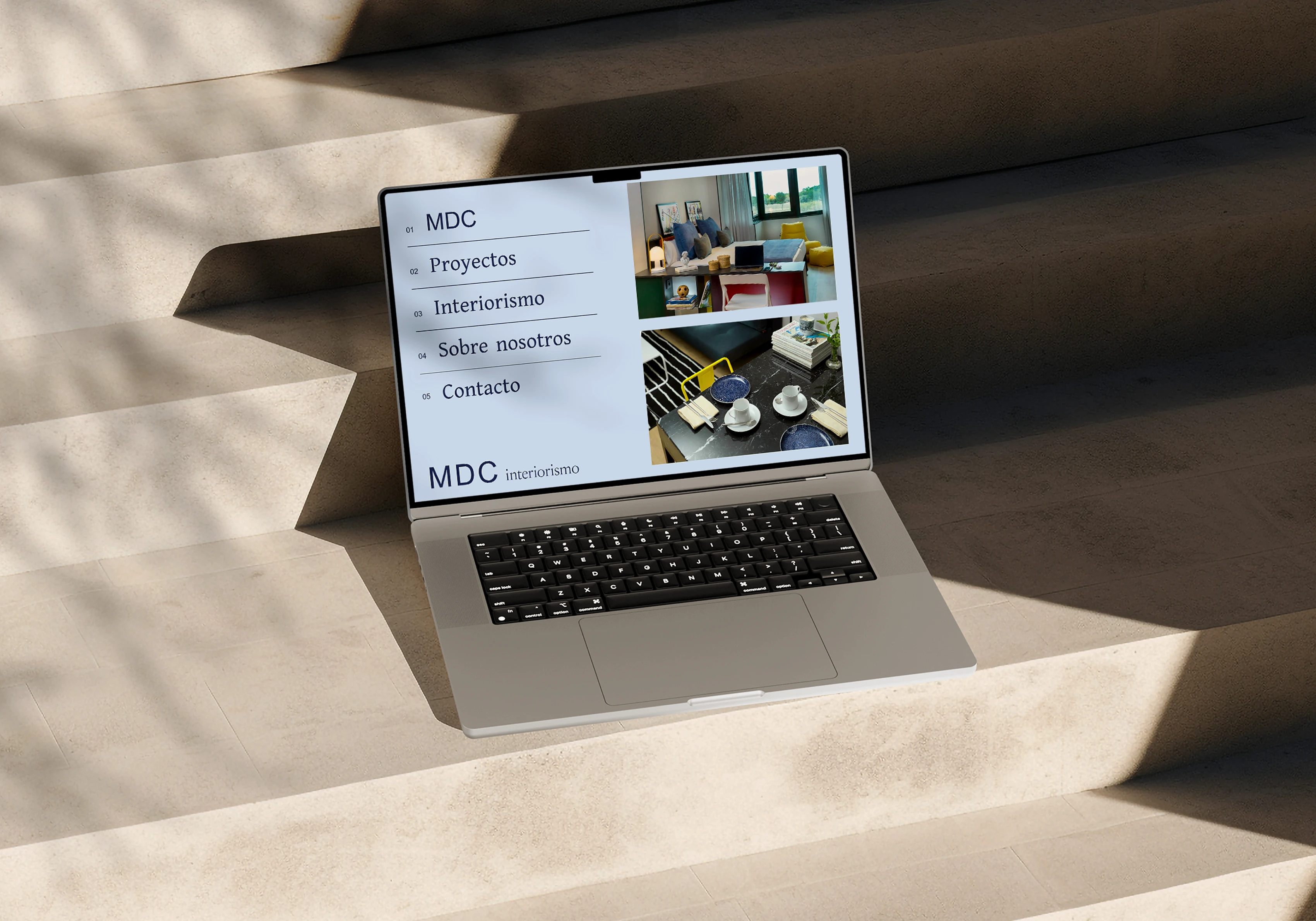 MDC Interiorismo website on a laptop