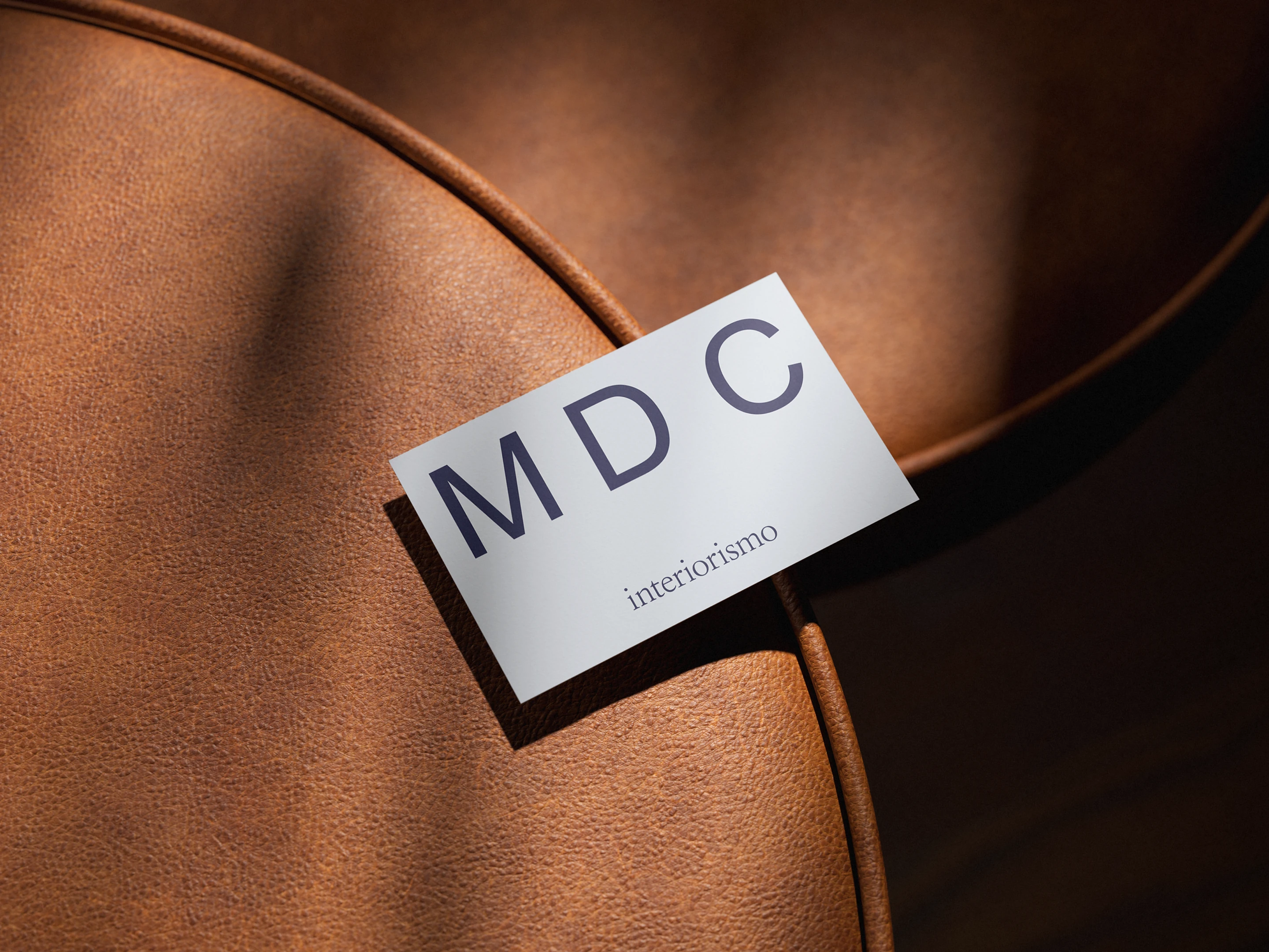 MDC Interiorismo business card on leather