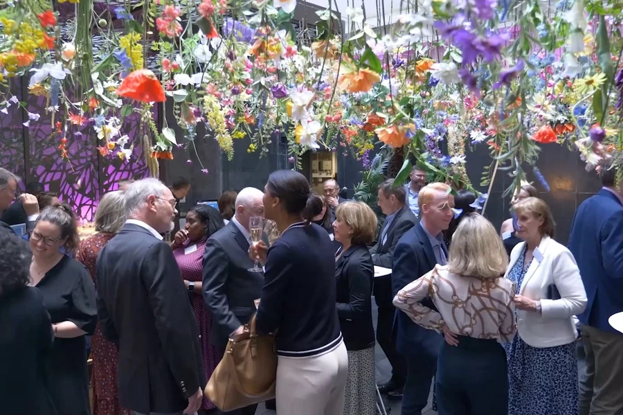 Guests at a Sheridan Worldwide event beneath hanging flowers